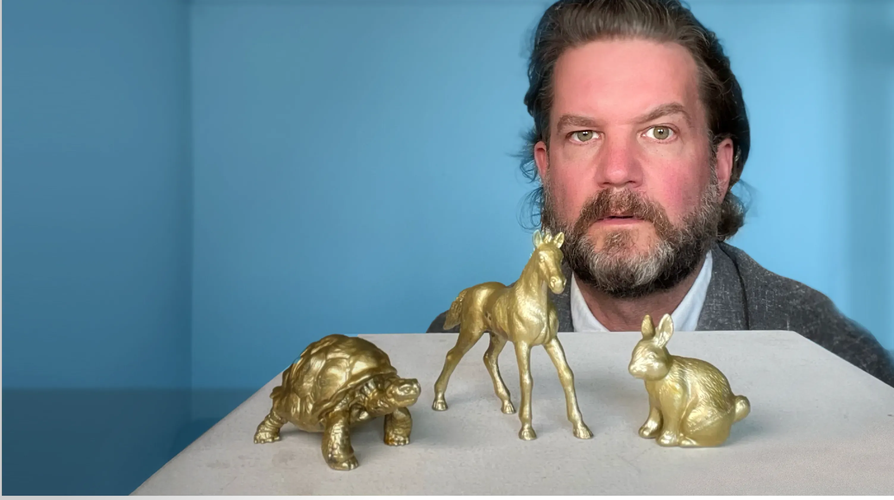 Philipp Erlach behind three gilded animal figures: tortoise, horse and rabbit