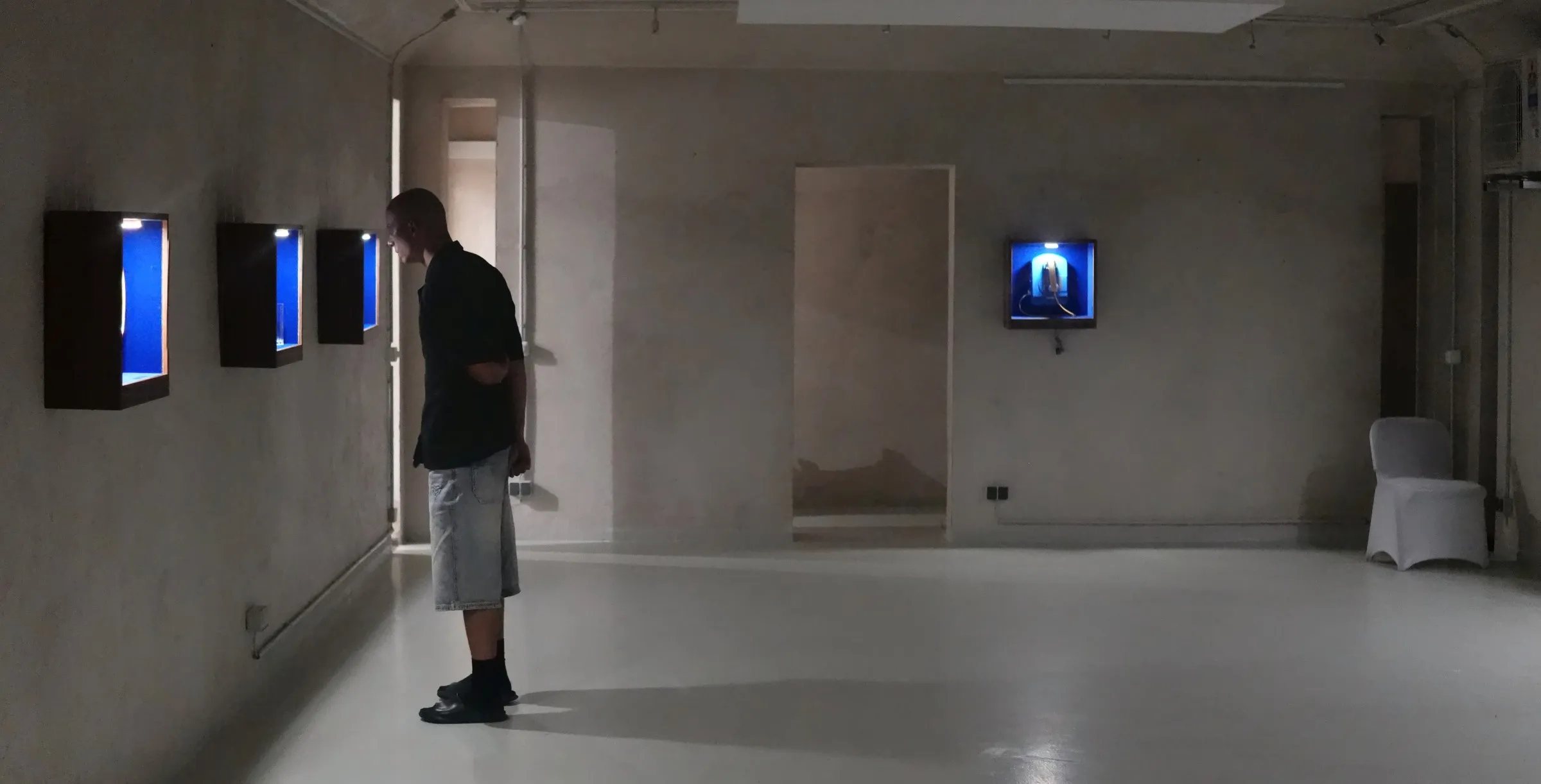 A visitor leaning towards the vitrines at Bunker West